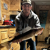 Walleye limit reduction proposal A person holding a walleye fish in a cabin.