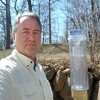 Person with a rainfall monitor outdoors