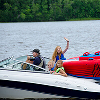 Water Safety A family wearing life jackets, enjoys boating safely on the water.