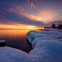 DNR 2025 accomplishments. Sunrise over a lake with ice forming at the edges